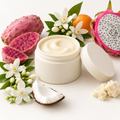Pink Volcano Butter Balm in an open rice husk jar with matching lid and fruit and floral scent props
