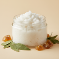 Patchouli Amber Body Scrub Travel Size in a clear 2oz jar with no label, with patchouli leaves and amber resin props