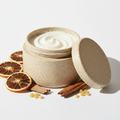 Rooted Joy Body Scrub in a rice husk jar with orange, cedarwood and frankincense props