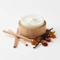 Sandalwood Body Butter Balm in open rice husk jar with sandalwood sticks and vanilla bean