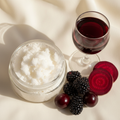 Scarlet Body Scrub Travel Size in a clear 2oz jar with no label, with dark berries, red wine and beet root props